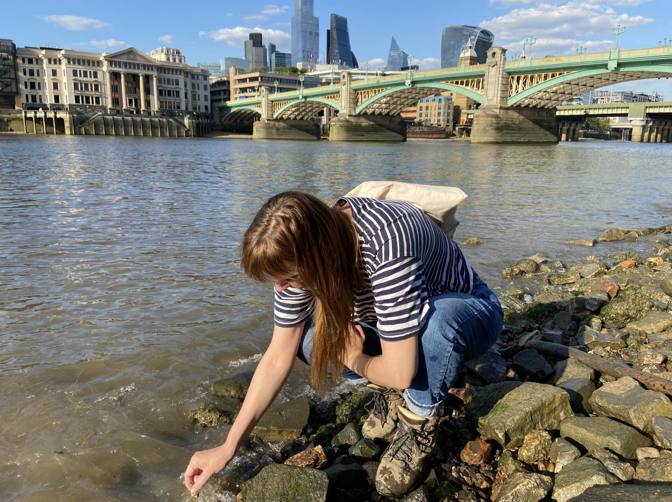 Artist collecting shells by the Thames
